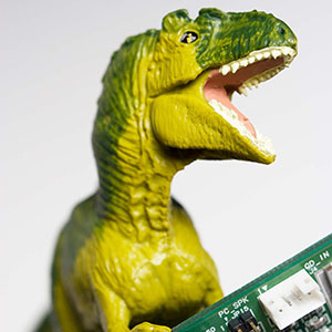 Photograph of a dinosaur holding a computer board