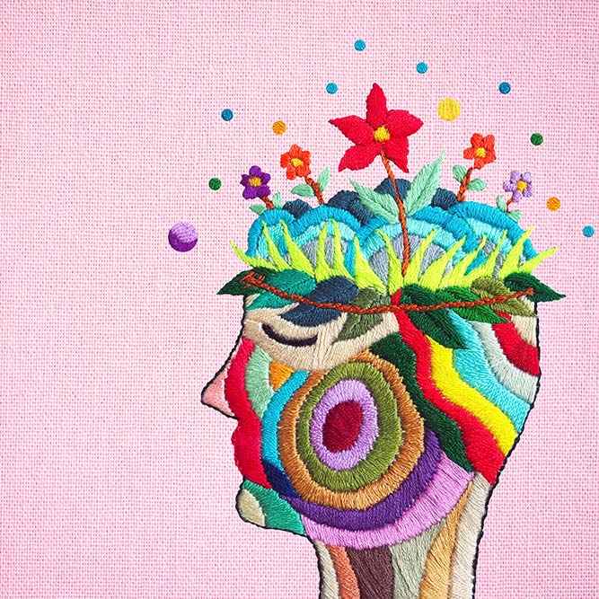 Embroidered art showing a colorful human head with flowers popping out